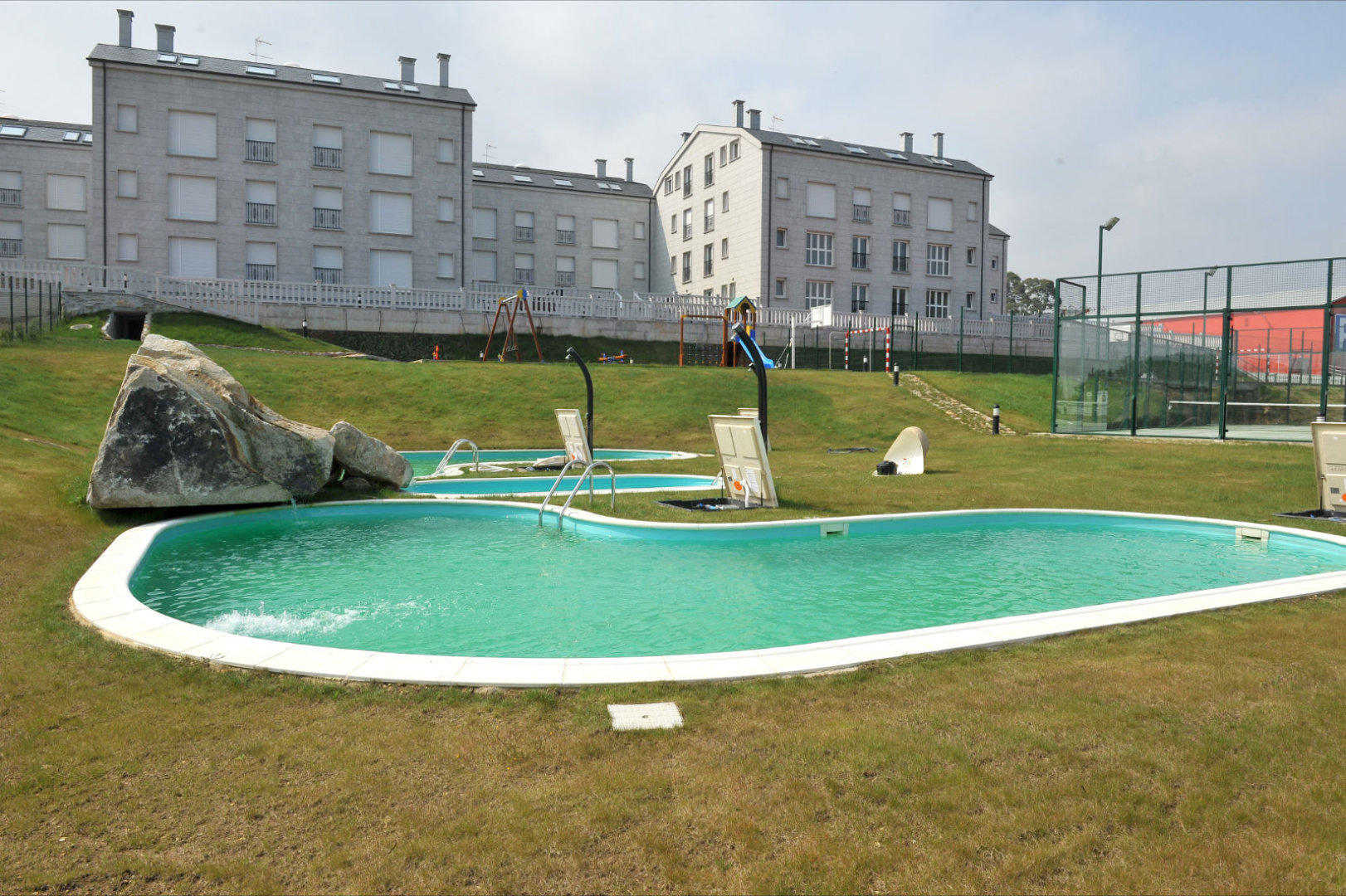 Piscina y amplias zonas ajardinadas en los Apartamentos Jardines de Lugo
