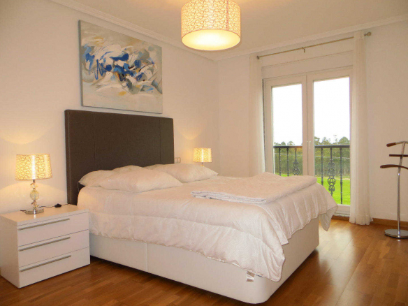 Dormitorio amplio con cama doble y decoración moderna en Jardines de Lugo